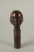 A BRONZE WALKING STICK HANDLE 'FOUR FACES'.