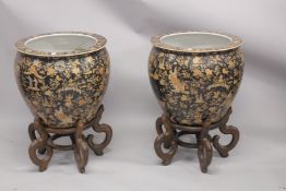 A LARGE PAIR OF CHINESE PORCELAIN FISH TANKS on wooden bases, Famille Noire with scrolls and