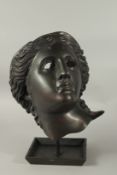A BRONZE FEMALE MASK on a stand. 34cms.