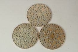 A SET OF THREE PIERCED SILVER AND GLASS PLATE STANDS. 15cms diameter.