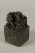 A CHINESE BRONZE DRAGON SEAL. 12cms high.