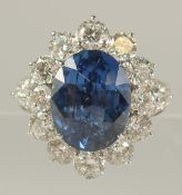 AN 18ct WHITE GOLD RING SET WITH AN OVAL-CUT BLUE SAPPHIRE AND RBC AND PEAR SHAPED DIAMONDS.