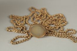 A LONG 9ct GOLD GUARD CHAIN AND FOB. 140cms long. Approx. 36grms.