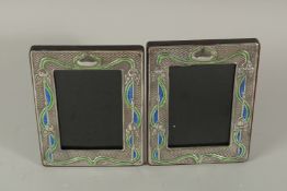 A PAIR OF SILVER AND ENAMEL ART DECO PHOTOGRAPH FRAMES. 21cms x 14cms.