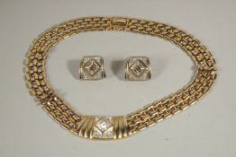 A GILT DIAMANTE NECKLACE AND EAR CLIPS in a blue bag.