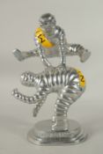A GILT METAL LEAP FROG MICHELIN MAN. 24cms high.