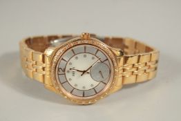 A GUESS GILT STAINLESS STEEL WRISTWATCH. W093113 with mother-of-pearl face.
