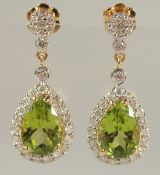 A PAIR OF 18ct YELLOW GOLD DROP EARRINGS SET WITH PEAR SHAPED PERIDOT AND RBC DIAMONDS, boxed.