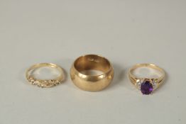A .750 GOLD WEDDING RING AND TWO OTHER RINGS.