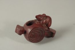 A JAPANESE HARDWOOD RAT CARVING on a barrel. Signed. 8cms long.