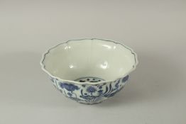 A CHINESE BLUE AND WHITE PORCELAIN PETAL SHAPED BOWL, decorated with fish and algae. 23cms wide.