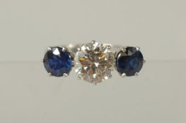 A SUPERB PLATINUM 2ct DIAMOND AND TWO SAPPHIRES RING. Diamond E. Colour with G. M. Certificate.