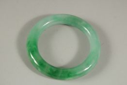 AN APPLE JADE BANGLE. 8cms diameter.