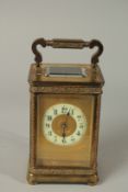 A 19TH CENTURY FRENCH BRASS CARRIAGE CLOCK with engraved face 