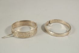TWO ENGRAVED SILVER BANGLES.
