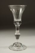 A GEORGIAN WINE GLASS with plain inverted bell bowl and knop stem. 7ins high.