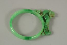 A LARGE JADE BANGLE WITH DOG OF FO. 8cms diameter.