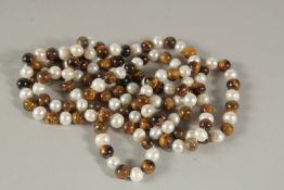 A STRING OF ONE HUNDRED AND TWENTY PEARLS AND TIGER'S EYE BEADS.