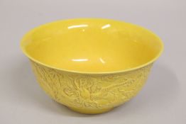 A CHINESE YELLOW GROUND PORCELAIN DRAGON BOWL, the exterior with carved dragons and stylised clouds,