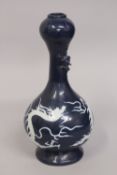 A CHINESE SACRIFICIAL BLUE GARLIC HEAD DRAGON VASE, with carved white dragon to the body, the neck