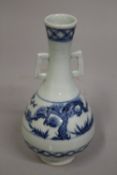 A CHINESE BLUE AND WHITE PORCELAIN TWIN HANDLE VASE, 21cm high.