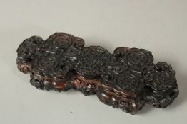 A VERY FINELY CARVED 19TH CENTURY CHINESE RUYI HARDWOOD STAND, with ornately carved roundels of