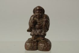 A BRONZE OKIMONO OF A MAN ON A RAFT, 6cm high.