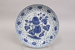 A CHINESE BLUE AND WHITE PORCELAIN CHARGER, painted with fruit and flora, 33cm diameter.