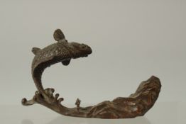 A BRONZE OKIMONO OF A CARP on a base of waves and a rocky mound, 12cm long.