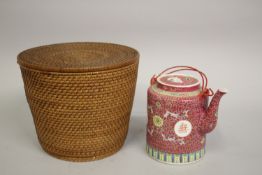 A PINK GROUND ENAMEL-PAINTED PORCELAIN TEAPOT, in fitted bamboo-woven case.