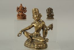 A 19TH CENTURY CHINESE BRASS BUDDHA, together with an Indian brass deity, and a carved sandalwood