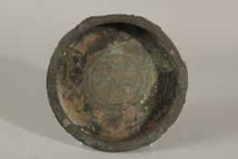 A 13TH CENTURY PERSIAN SELJUK BRONZE DISH, the centre depicting a mythical creature, 15cm diameter.
