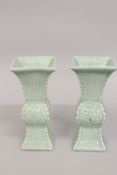 A PAIR OF CHINESE CELADON GLAZED PORCELAIN QUADRANGULAR VASES, with carved archaic style decoration,