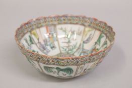 A CHINESE FAMILLE VERTE PORCELAIN BOWL, with scalloped rim and painted with panels of figures,