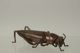 A BRONZE OKIMONO OF A GRASSHOPPER, 8.5cm long.