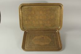 TWO 19TH CENTURY PERSIAN QAJAR ENGRAVED BRASS TRAYS, one depicting seated figures and musicians, the