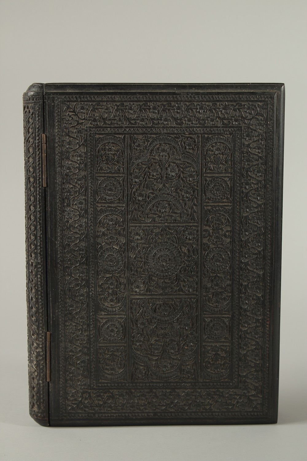 A MID 19TH CENTURY ANGLO INDIAN FINELY CARVED EBONY HINGED BOOK COVER, 30cm x 22cm.