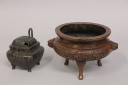 A CHINESE BRONZE TRIPOD CENSER, with foliate designs and lion dog handles, the base with character