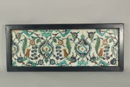 THREE ISLAMIC GLAZED POTTERY FLORAL TILES UNITED IN A WOODEN FRAME, 33cm x 82cm overall.