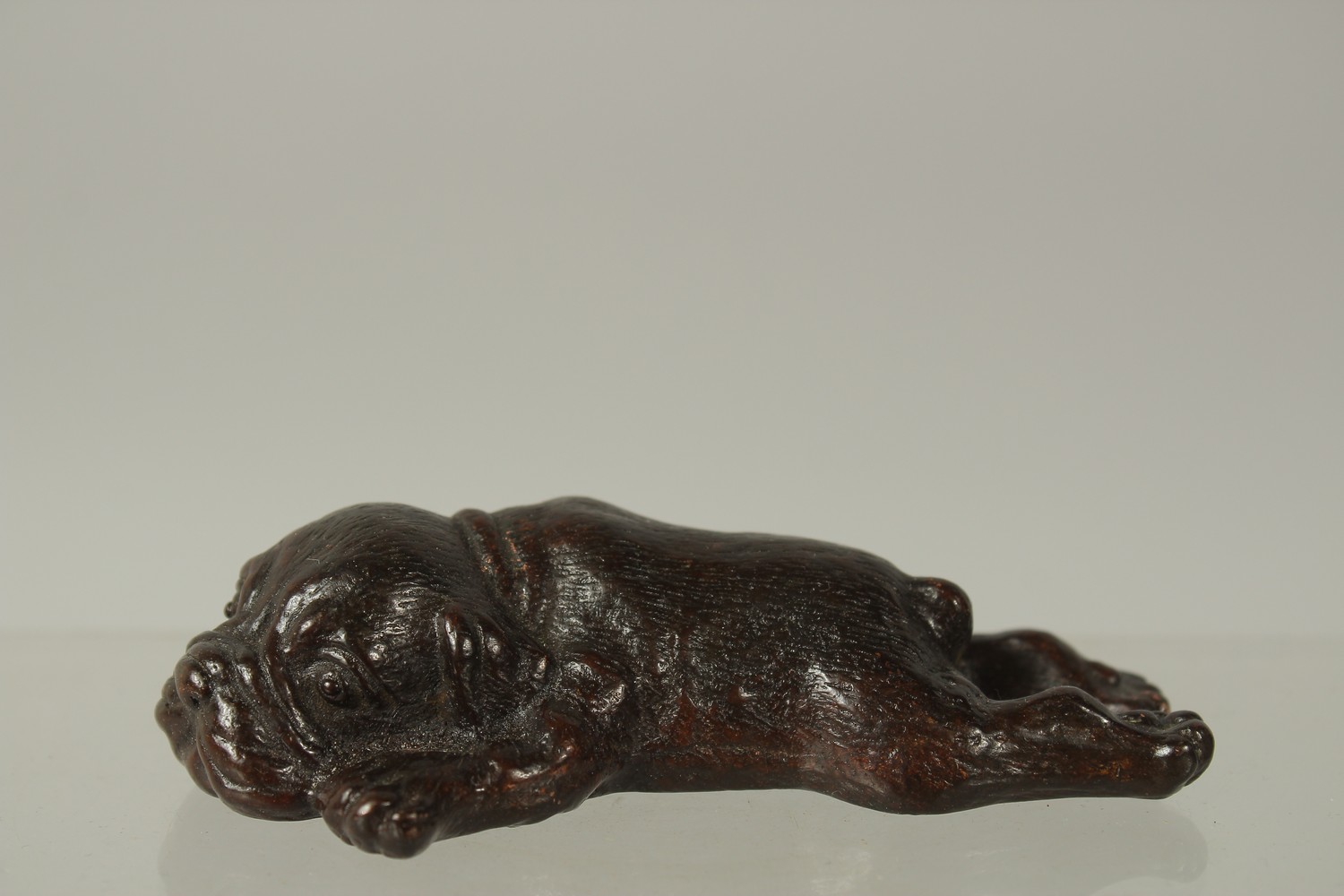 A BRONZE OKIMONO OF A SLEEPING DOG, 9.5cm long.
