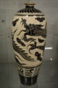 A large Chinese pottery vase incised with a dragon design.