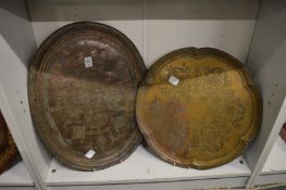 An Islamic engraved copper tray and a brass tray with engraved decoration.