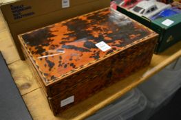 A tortoiseshell veneered sewing box with fitted interior.