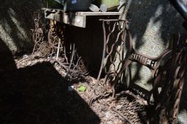 Three cast iron singer sewing machine bases, two with wooden tops.