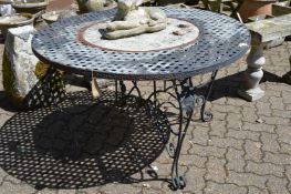 A circular metal garden table inset with a pottery plaque.