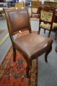 A mahogany and leather upholstered desk chair.