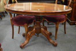 A Victorian mahogany and inlaid oval tilt-top breakfast table.