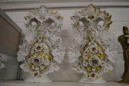 A pair of decorative floral encrusted vases (some restoration).