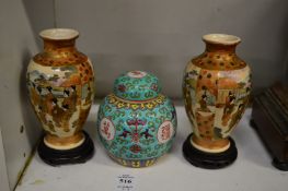 A pair of Japanese satsuma vases painted with figures together with a small ginger jar and cover.