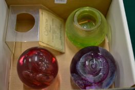 Two glass paperweights and a green glass match striker.